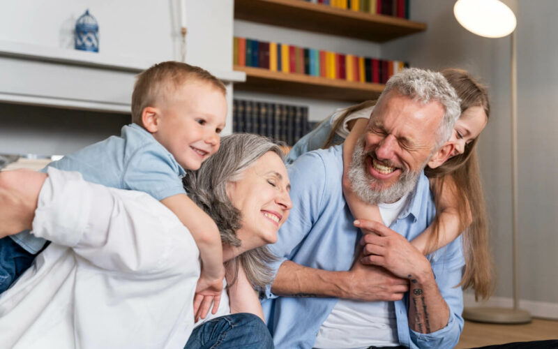babcia i dziadek trzymają wnuki na barana. Wszyscy się śmieją. To wyjątkowa relacja z dziadkami.